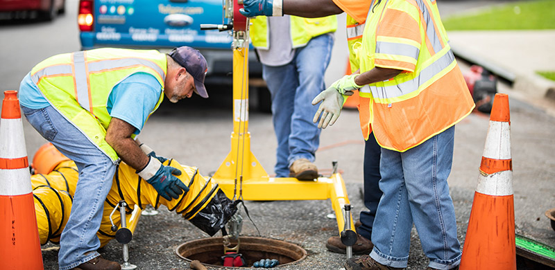 a crew inspecting a storm sewer drain